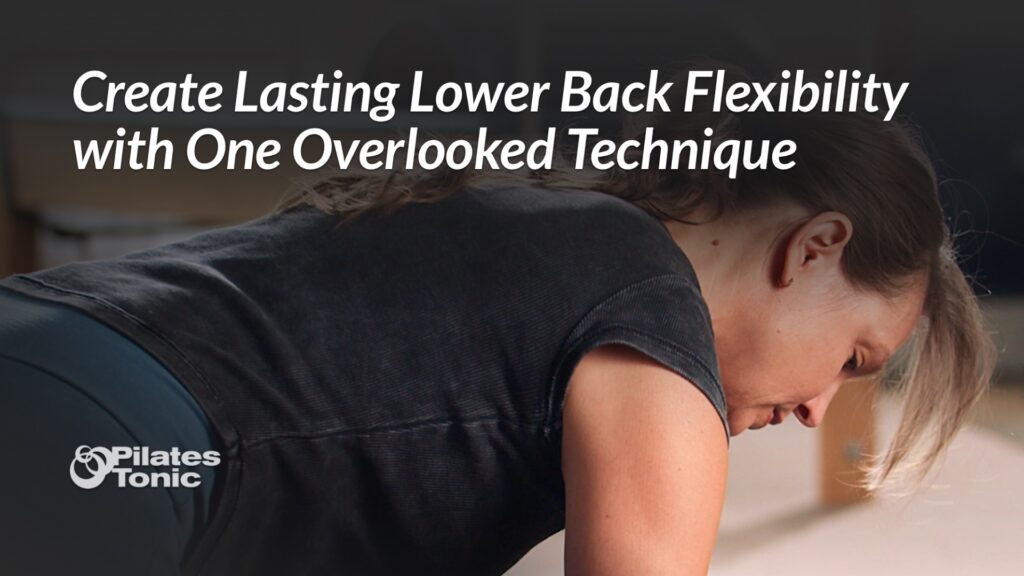 Woman in black shirt performing spinal flexion exercise on Pilates equipment to improve lower back flexibility.