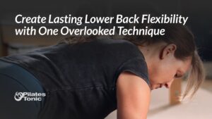 Woman in black shirt performing spinal flexion exercise on Pilates equipment to improve lower back flexibility.